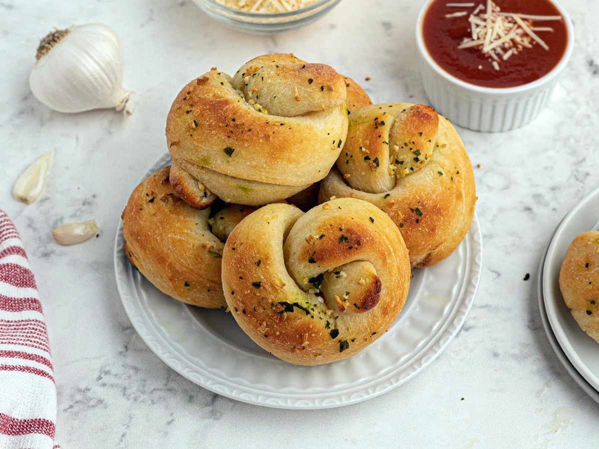 Healthy Italian Recipes Homemade Garlic Knots Decorated with Garlic Cloves and Marinara Sauce